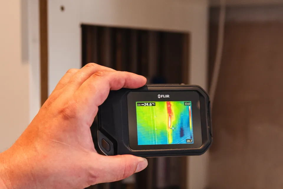 Thermal imaging camera showing a hot pipe run hidden behind a kitchen unit